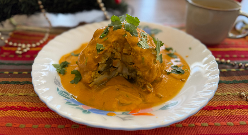 Image of Gobi Mussalam, a whole cauliflower cooked in rich curry gravy, served as a vegan, gluten-free and dairy-free Indian dish garnished with fresh herbs.